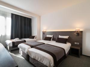 a hotel room with two beds and a large window at Hotel Best Western City Centre in Brussels