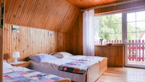 ロビにあるRowiankaの木製の壁のベッドルーム1室(ベッド2台付)