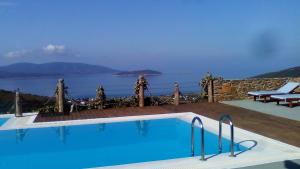 a swimming pool with a view of the water at Celini Suites Hotel in Marmari