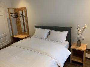 a bed with white sheets and pillows in a bedroom at Millrather Brauhaus in Erkrath