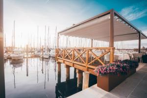 a marina with tables and flowers on a dock at Mosella Suite Hotel in Sottomarina