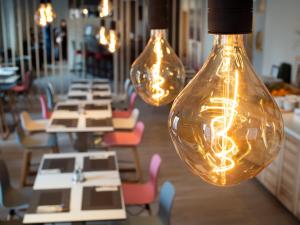 a row of lights hanging over tables in a restaurant at Hotel Best Western City Centre in Brussels