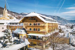 ein großes Gebäude mit Schnee auf dem Dach in der Unterkunft Hotel & Restaurant Wastlwirt in Sankt Michael im Lungau