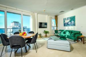 uma sala de estar com uma mesa e um sofá verde em Picturesque 3BR Apt w Balcony & Parking Near Beach by Sea N' Rent em Tel Aviv