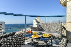 a tray of food on a table on a balcony at Picturesque 3BR Apt w Balcony & Parking Near Beach by Sea N' Rent in Tel Aviv