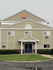 un grand bâtiment avec une porte bleue et un toit orange dans l'établissement InTown Suites Extended Stay Columbus OH - North, à Columbus