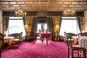 a dining room with tables and chairs and windows at Hotel & Restaurant Wastlwirt in Sankt Michael im Lungau