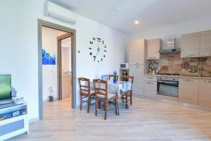 a kitchen with a table and chairs and a clock on the wall at Il Profumo di Capri in Massa Lubrense