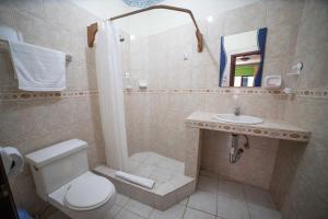 a bathroom with a toilet and a sink at Hostal Gladismar in Puerto Villamil