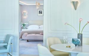 a room with a bed, chair, table and a mirror at One Aldwych in London