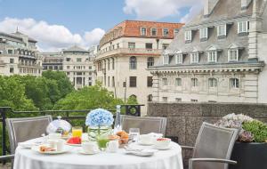 a table with a white table cloth on a balcony with buildings at One Aldwych in London