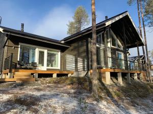 a house with a wrap around porch and a deck at Villa LumiHelmi A & B in Äkäslompolo