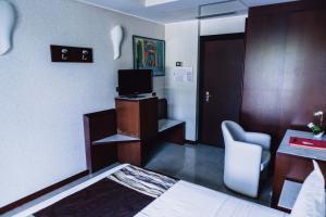 a hotel room with a bed and a desk and a television at Mare Hotel in Savona