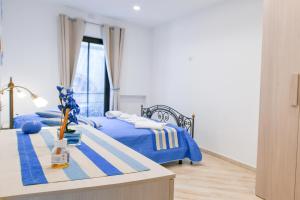 a bedroom with two beds with blue sheets and a table at Il Profumo di Capri in Massa Lubrense