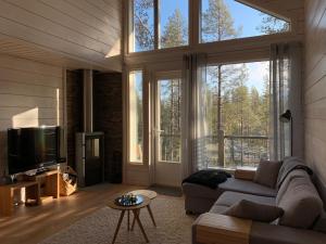 sala de estar con sofá y ventana grande en Villa LumiHelmi A & B en Äkäslompolo