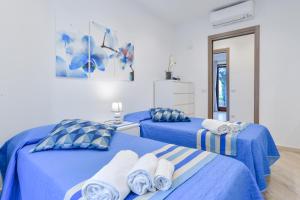 two beds in a room with blue and white at Il Profumo di Capri in Massa Lubrense