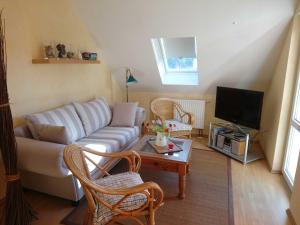 a living room with a couch and a tv at Ferienwohnung Heiden _ 100m bis zu in Ostseebad Karlshagen