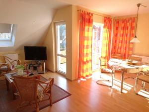 a living room with a table and chairs and a television at Ferienwohnung Heiden _ 100m bis zu in Ostseebad Karlshagen