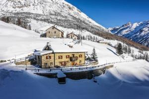 a house in the snow in front of a mountain at Baita Luleta in Livigno