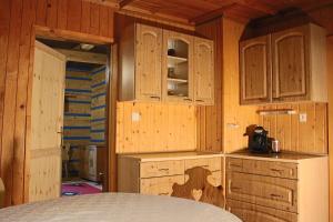 a kitchen with wooden cabinets and a woman painted on it at Chalupa Za lesíkom in Ždiar