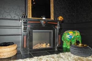 a living room with a fireplace and a chair at Koto Garden Suites in Antwerp