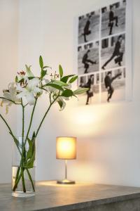 un vaso di fiori seduto su un tavolo con una lampada di Newton-Appartement mit 3 Schlafzimmern a Berlino