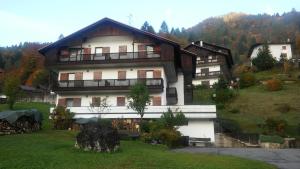 a large white building with a balcony on a hill at Appartamenti Dolomiti in Colcerver