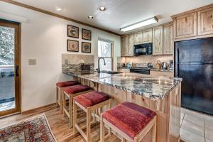 a kitchen with a large island with bar stools at Mountainside 673 Home in Frisco