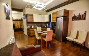 a kitchen and dining room with a table and a refrigerator at Freedom Square Apartment in Tbilisi City