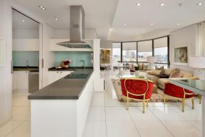 a kitchen and living room with a table and chairs at Sandton Skye Premium Suites & Penthouses in Johannesburg