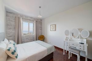a bedroom with a bed and a desk with mirrors at Alegria I by An Island Apart in Funchal