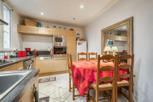 a kitchen with a table and chairs and a refrigerator at Une maison comme un Riad in Vincennes