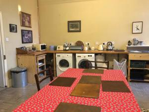 a kitchen with a table and a washing machine at Caynham Court in Ludlow