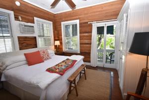 a bedroom with a white bed and windows at Simonton Court Historic Inn & Cottages in Key West