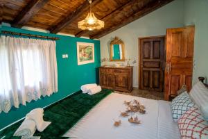 a green bedroom with a bed and a sink at Eleni Country Cottage 2 in Feneos