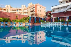 una piscina de agua frente a algunos edificios en Udalla Park - Hotel & Apartamentos, en Playa de las Américas