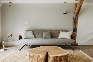 a living room with a couch and a tree stump coffee table at La Dime de Giverny - Cottages in Giverny