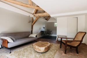 La Dime de Giverny - Cottages في جيفرني: غرفة معيشة مع أريكة وطاولة