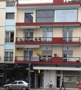 a building on a city street with a person on a bike at G & G guesthouse in Edessa