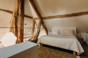a bedroom with a bed and wooden beams at La Dime de Giverny - Cottages in Giverny