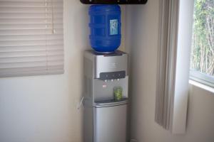 a water cooler with a blue bucket on top of it at Hostal Gladismar in Puerto Villamil