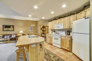 a kitchen with wooden cabinets and a white refrigerator at Tucker Mountain Lodge 102 Condo in Copper Mountain