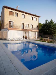 ein Haus mit einem Swimmingpool vor einem Gebäude in der Unterkunft Casa Rural Mirando a Gredos in Cadalso de los Vidrios