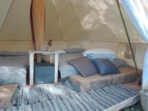 a tent with a table and pillows in it at Rifugio Manfre Bivouac Tent in Belpasso