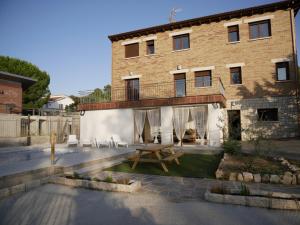 ein Haus mit einem Tisch und Stühlen davor in der Unterkunft Casa Rural Mirando a Gredos in Cadalso de los Vidrios