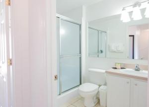 Baño blanco con aseo y lavamanos en Berkley Lake Townhomes, en Kissimmee