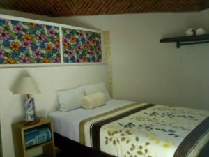 特基斯基亞潘的住宿－Hotel Casa Pahpaqui，卧室配有一张床,墙上挂有绘画作品