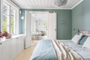 um quarto com paredes azuis, uma cama e uma sala de jantar em Peaceful, Picturesque Lake & Forest Retreat em Estocolmo