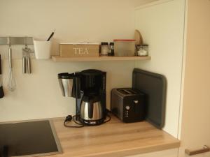 a kitchen counter with a coffee maker and a tv at Ferienwohnung am Schöhsee in Plön +20 photos