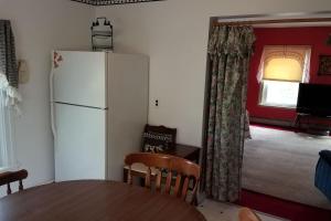 a kitchen with a table and a white refrigerator at The Open Door in Jefferson NY in Jefferson